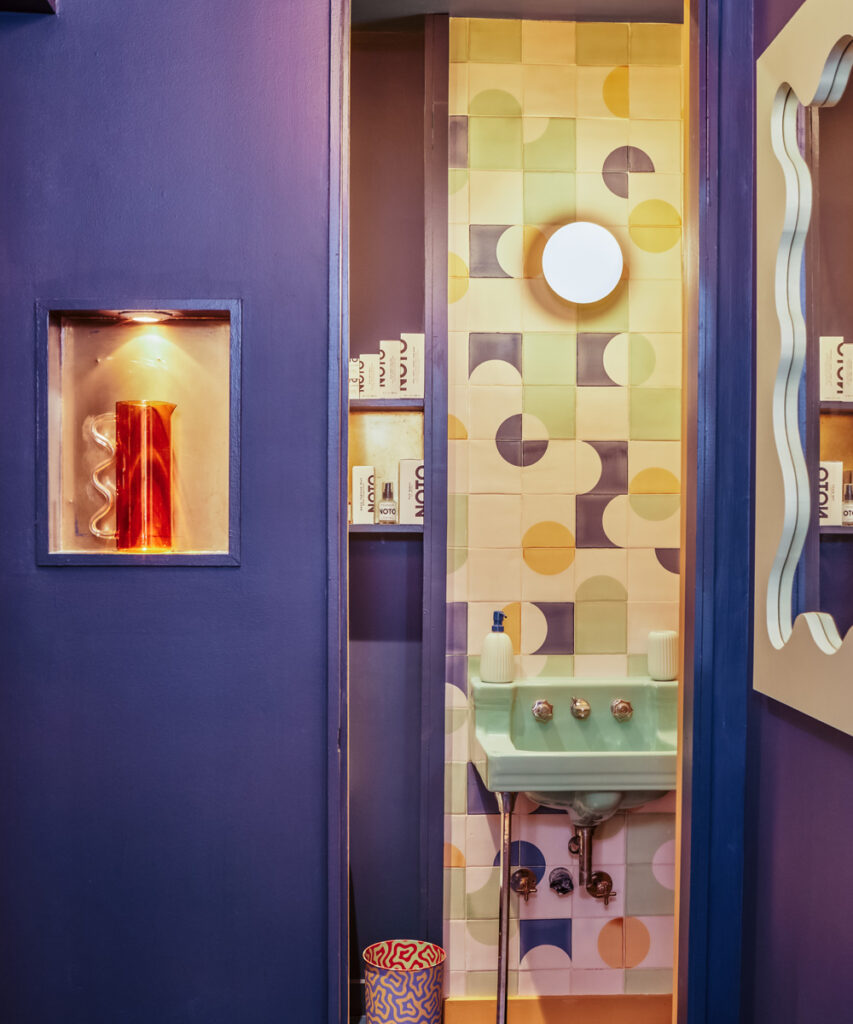 Small washroom at the Big Night shop in New York, lined with Smink Studio glazed ceramic tiles in lilac, yellow and cream shapes.