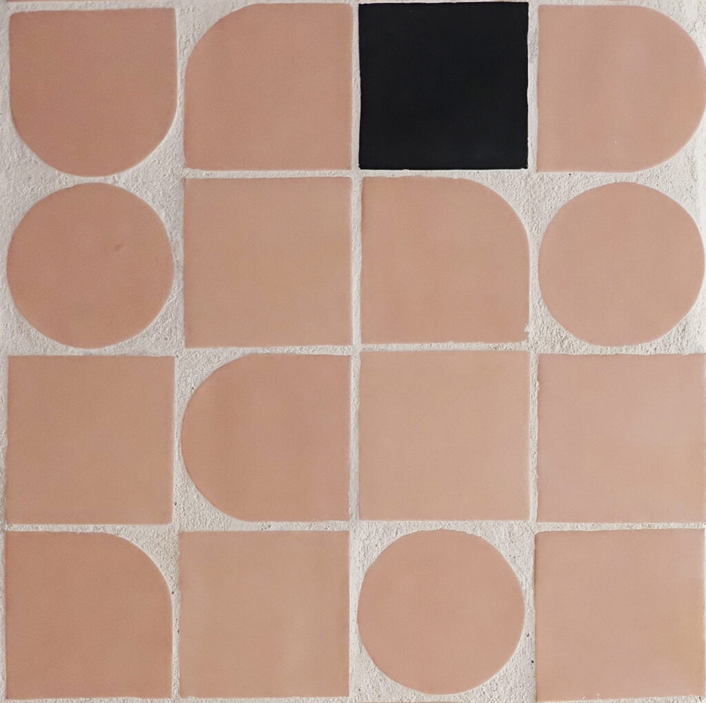 Close-up of blush-pink Smink Studio shaped handmade tiles, circles, arches and rounded squares, with one black square tile.