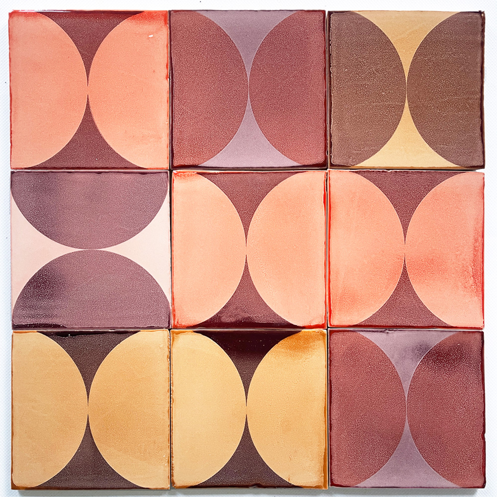 Nine Smink Studio handmade tiles with screen-printed half-circles in plum, peach, terracotta and ochre glazes, arranged in a square grid.