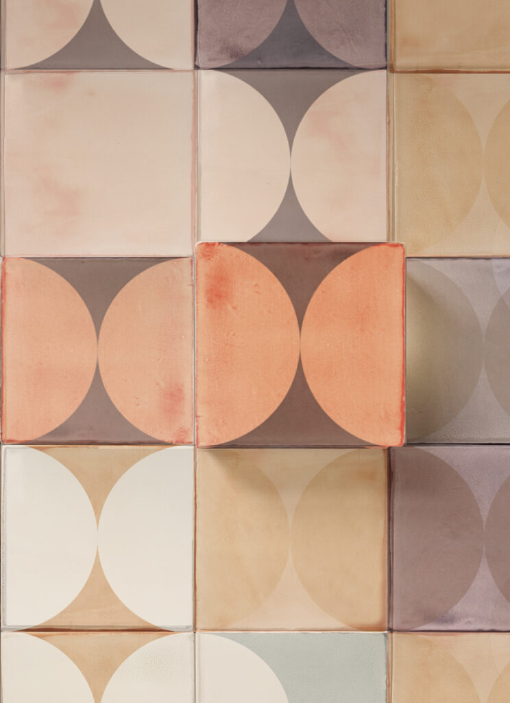 Close-up of Smink Studio handmade glazed ceramic tiles with screen-printed half-circles in peach, cream, sand and grey, made for the Biennale project.