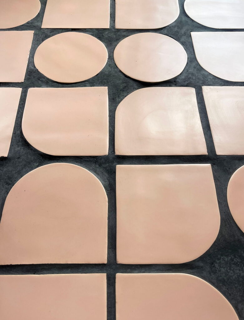 Smink Studio shape tiles in blush pink, including circles, ovals and arches, set in dark charcoal grout to test the contrast between tile and joint.