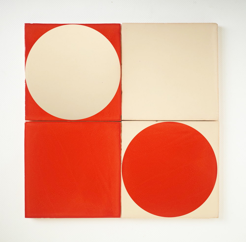 Four Smink Studio tiles in red and cream, two plain and two screen-printed with a circle, the two colours reversed between them.
