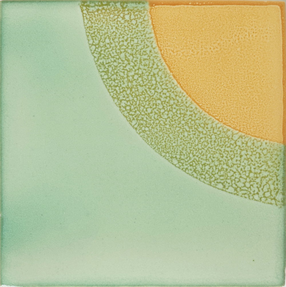 Close-up of a Smink Studio tile in pale green with a speckled olive arc and a mustard yellow quarter-circle, combining the Sunrise and Squared designs.