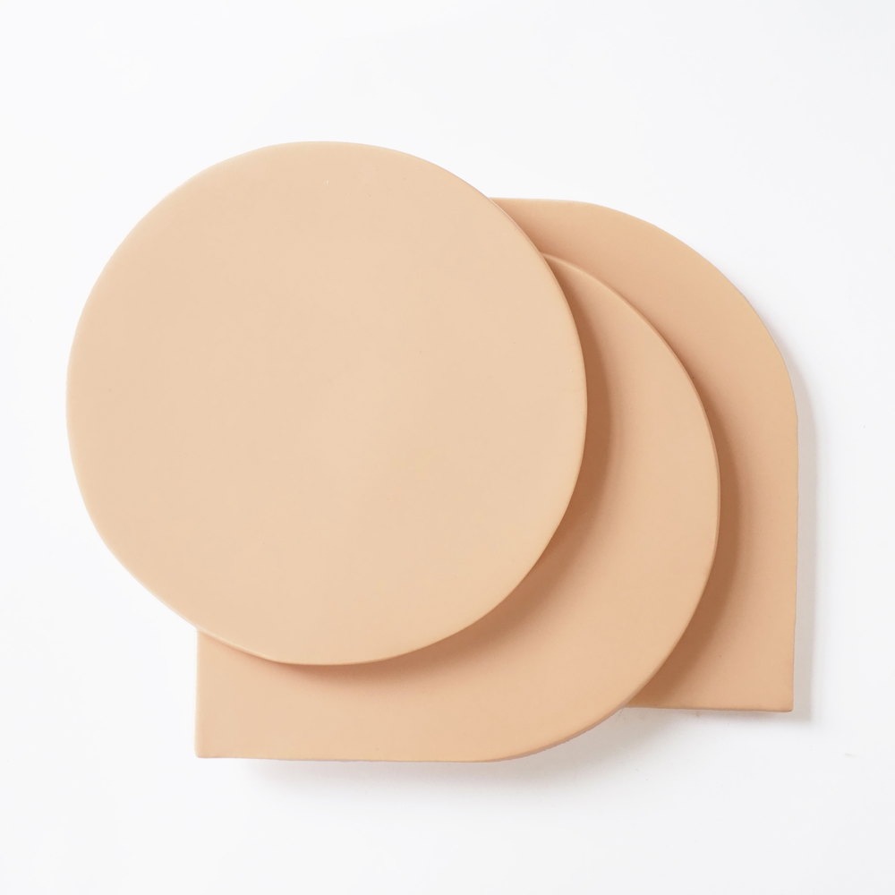 Two blush pink Smink Studio shape tiles overlapping on a white ground, a full circle resting on a square with one rounded corner.