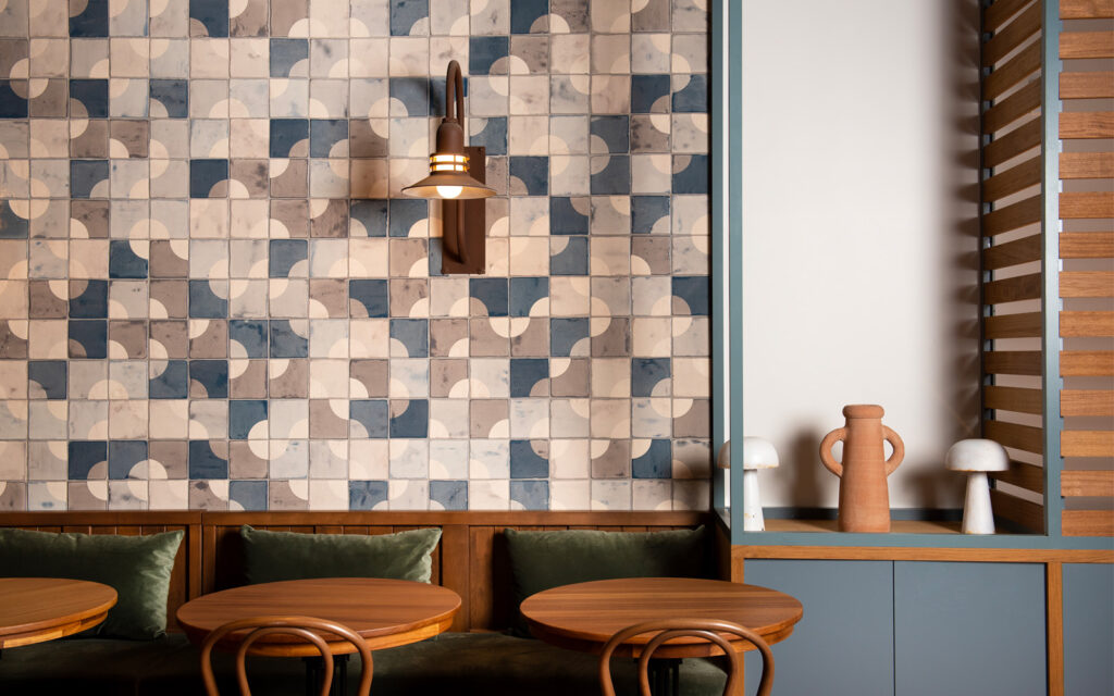 Bar Harta at the Grayson Hotel, New York: a wall of Smink Studio Quarter Circle tiles in navy, sand and cream above green banquettes.