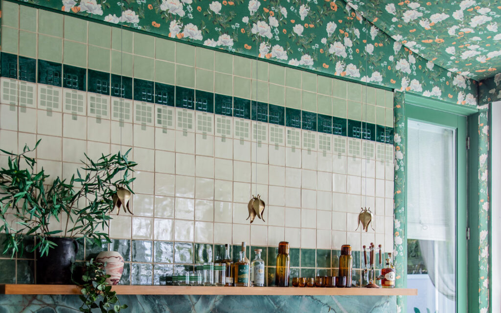Bar at the Kips Bay Show House by Redmond Aldrich Design: cream Smink Studio tiles with deep green bands, beneath floral wallpaper.