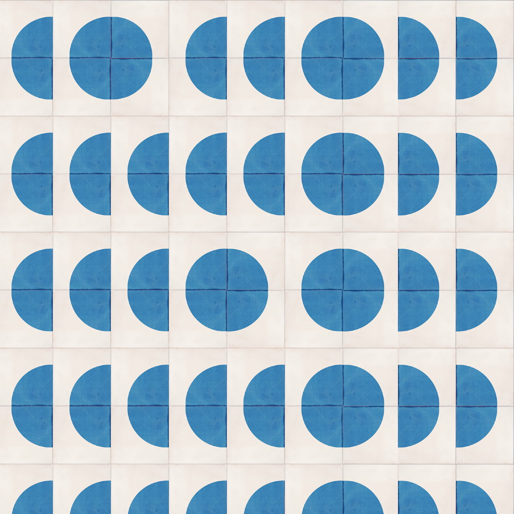Smink Studio handmade tiles in white screen-printed with bold blue circles and half-circles in a regular grid, from the Round windows, tall buildings design.