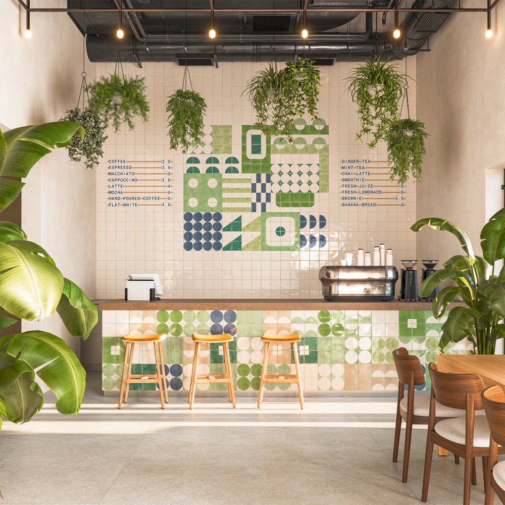 Cafe interior with the counter front and back wall tiled in Smink Studio handmade tiles in green, navy and cream geometric shapes, with hanging plants and oak bar stools.